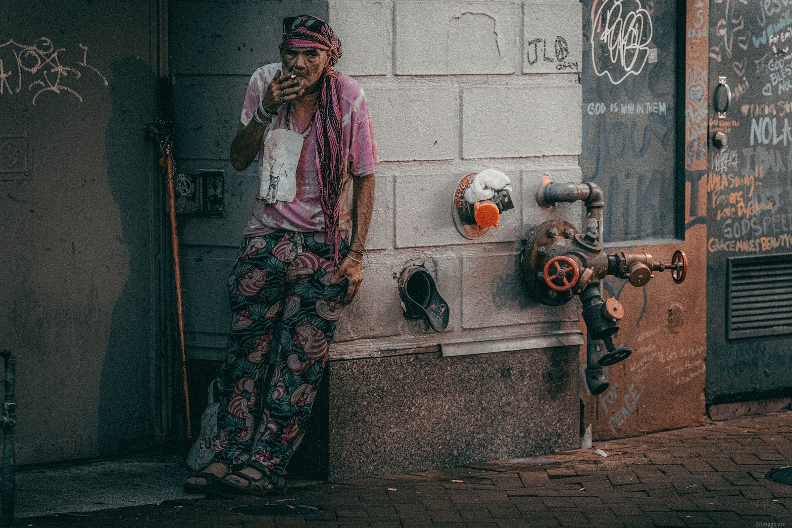 Solitary figure walking through a narrow alleyway, moody street photography