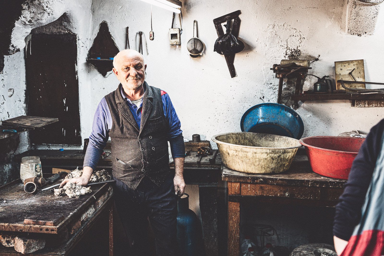 Artisan at work in a dimly lit workshop surrounded by handmade goods, Istanbul, Turkey